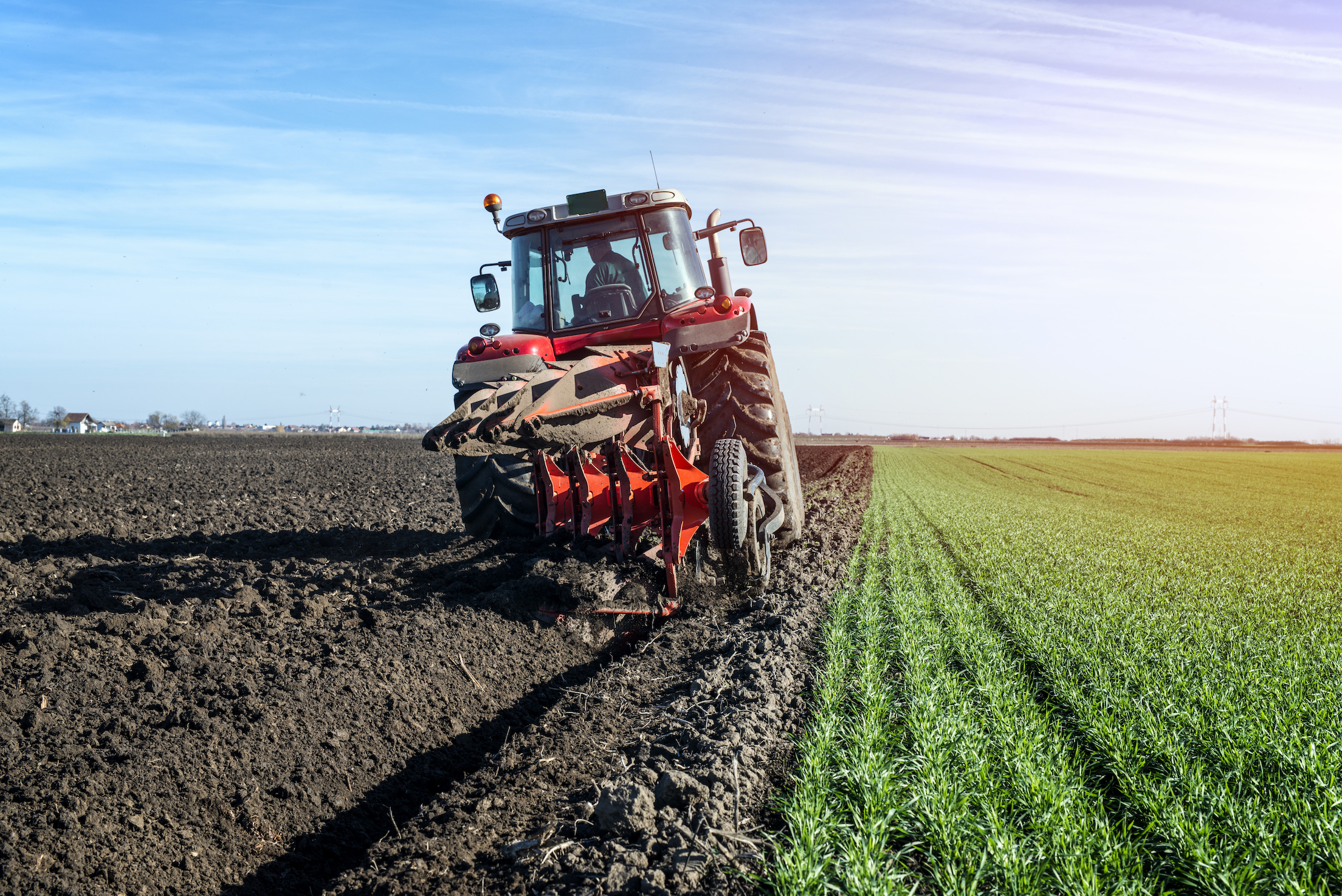 Tractor agricultural machine cultivating field.